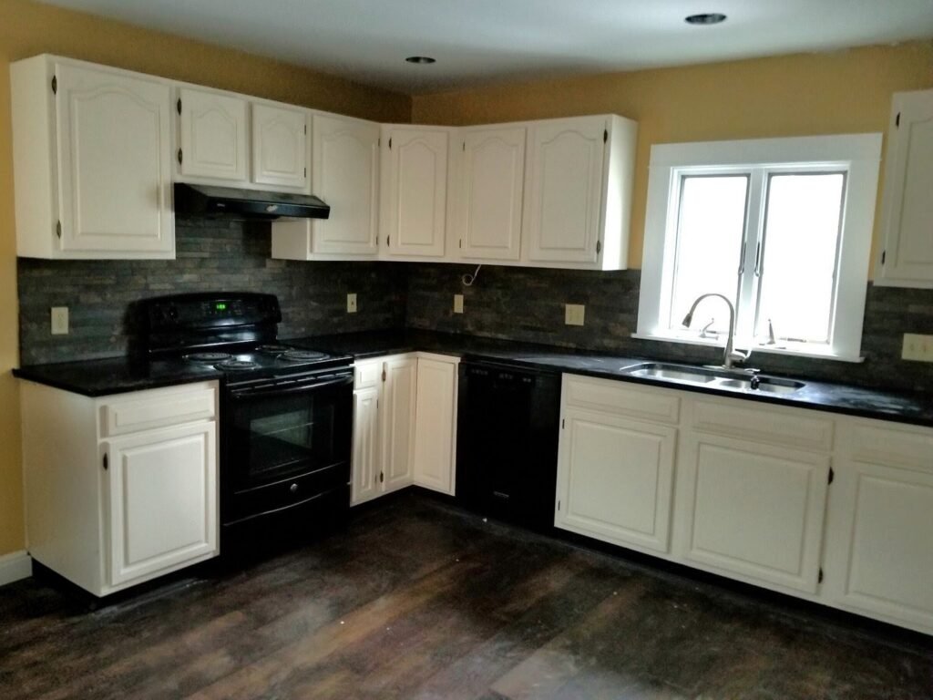 After shot of modern white cabinets set against black appliances in a refreshed kitchen