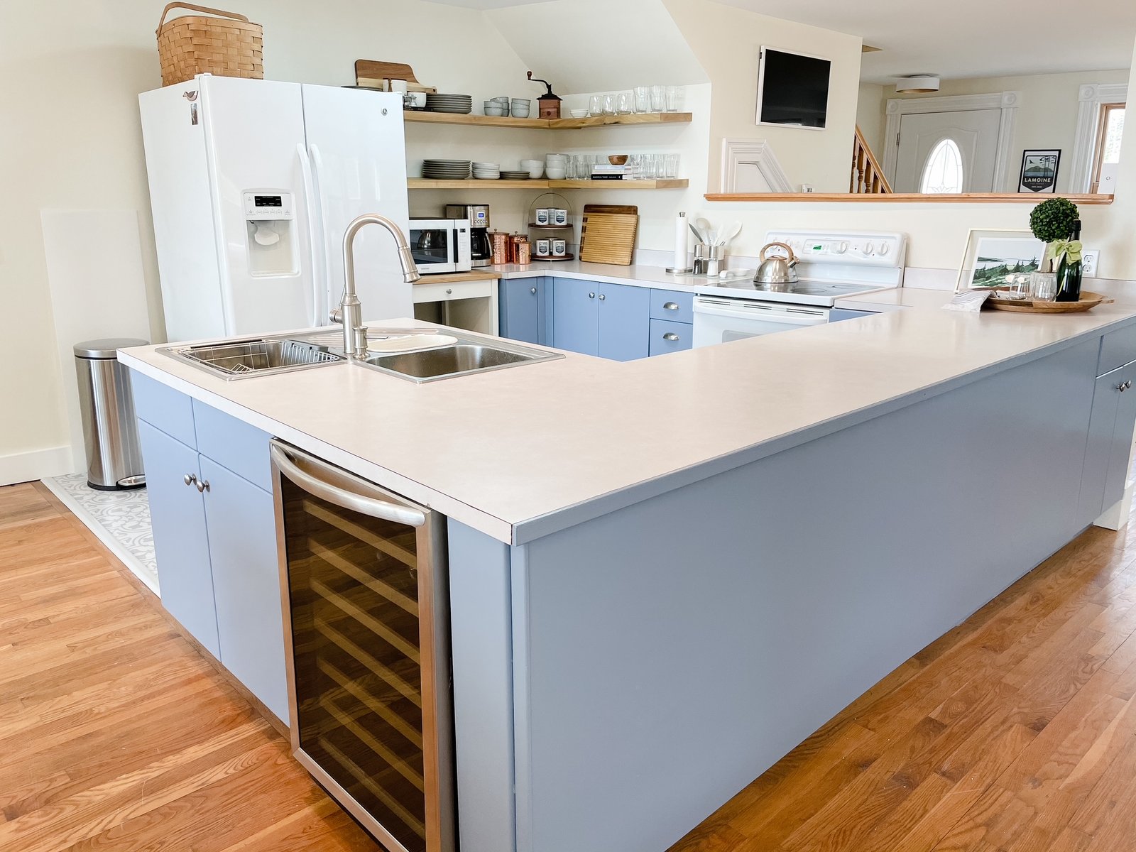 The finished view of a cornerstone kitchen with a light blue finish and white top on the island