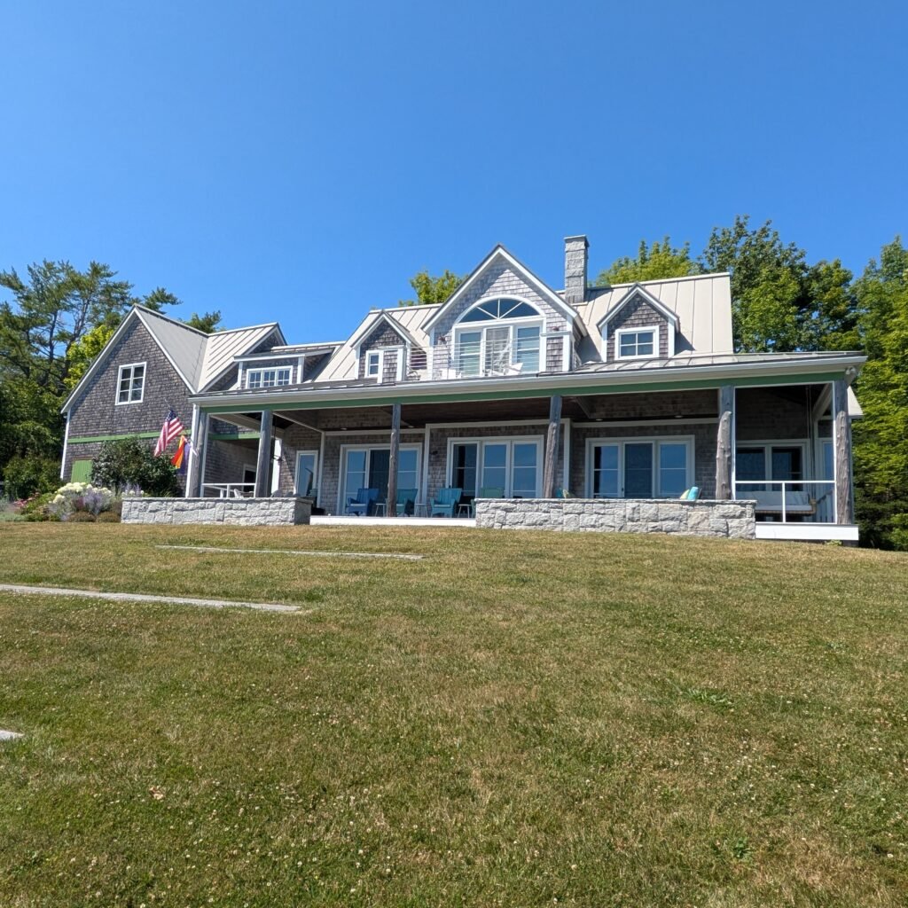 Chartreause trim grand house by the waterfront viewed from the lawn