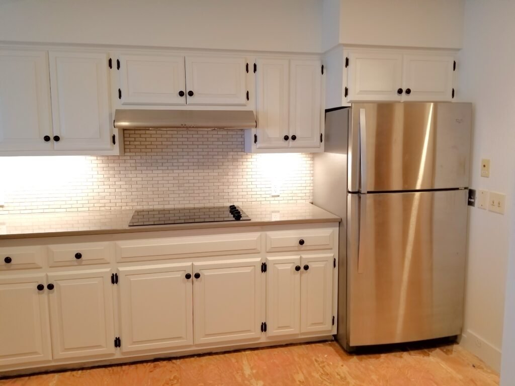 White cabinets fit perfectly with a steel refrigerator in a newly renovated kitchen