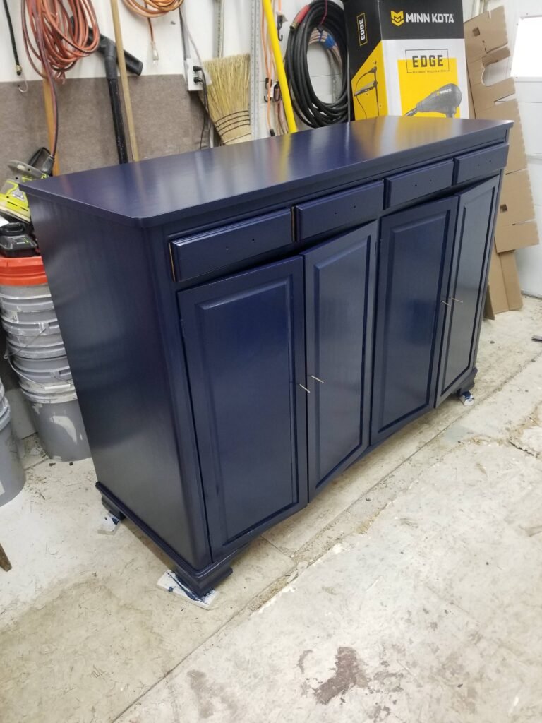 The blue cabinet that was seen disassembled in another photo is now assembled with a shiny finish coat of blue paint