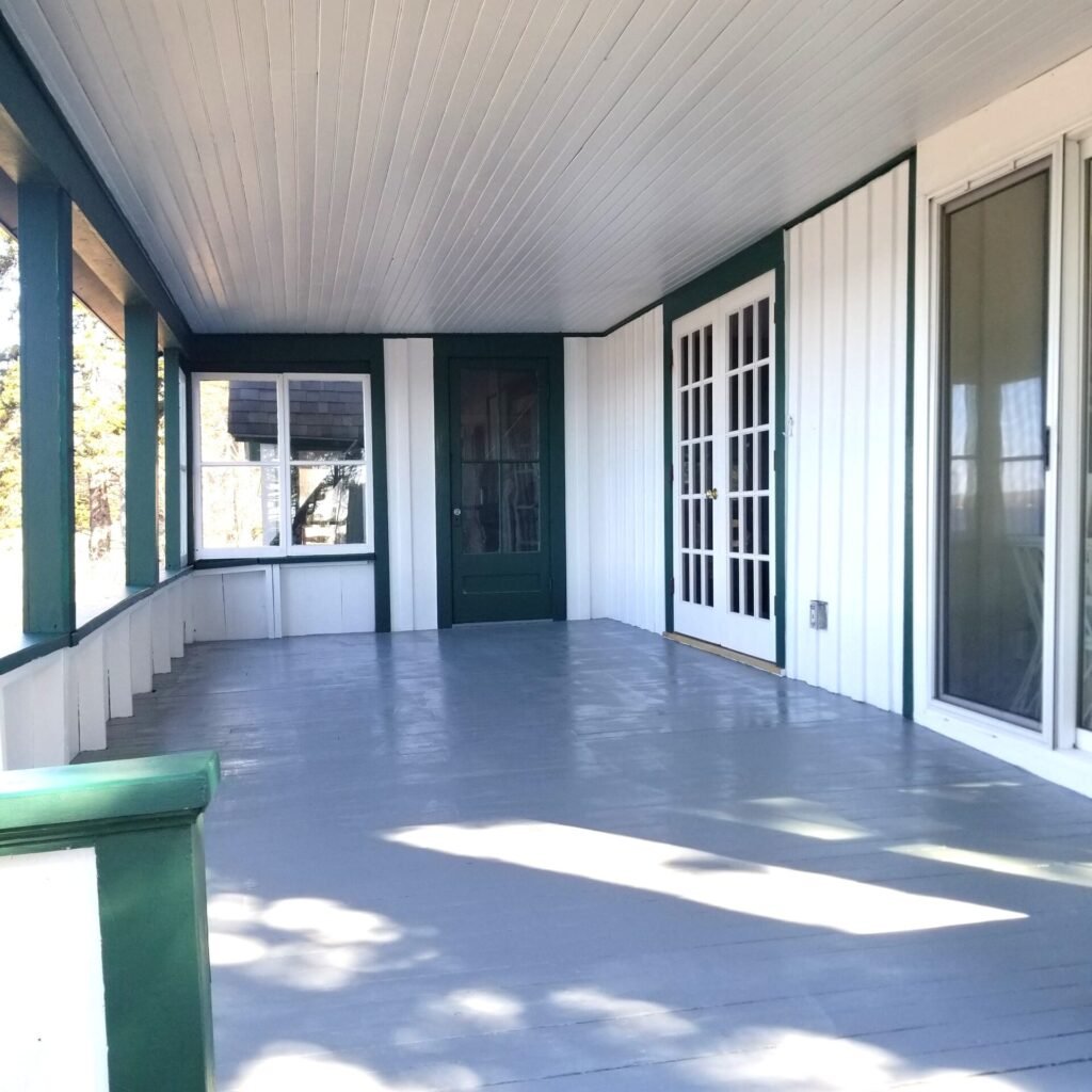 Freshly painted white porch with green trim