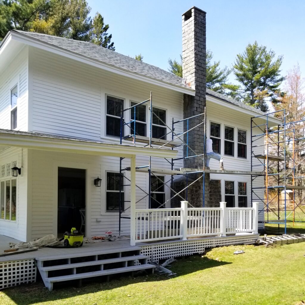 A white two story house with staging is set up