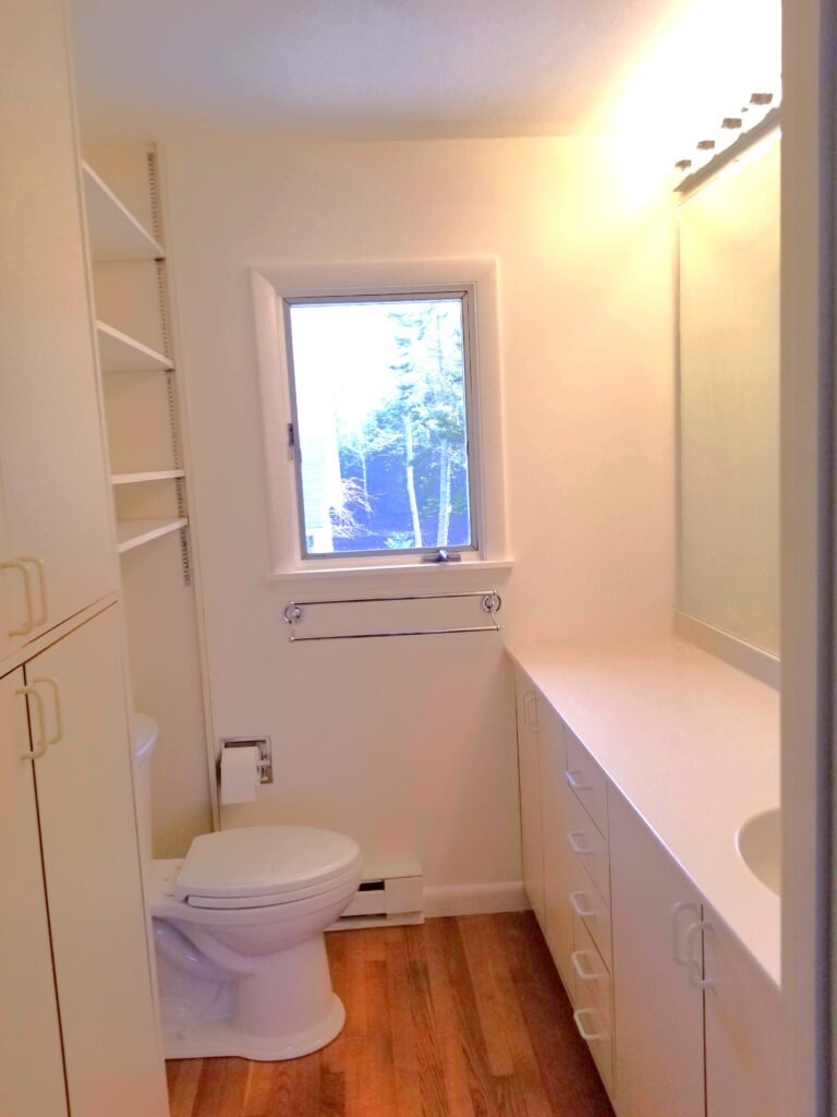 The after shot of an interior bathroom where the wallpaper was previously seen peeling, now with a fresh coat of creamy paint and no signs of wear and tear.
