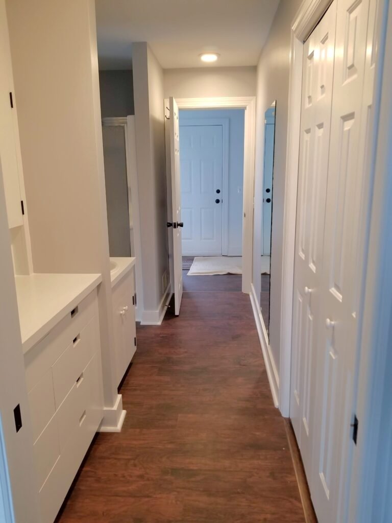 A hallway shot with multiple white closet doors and a single hallway light